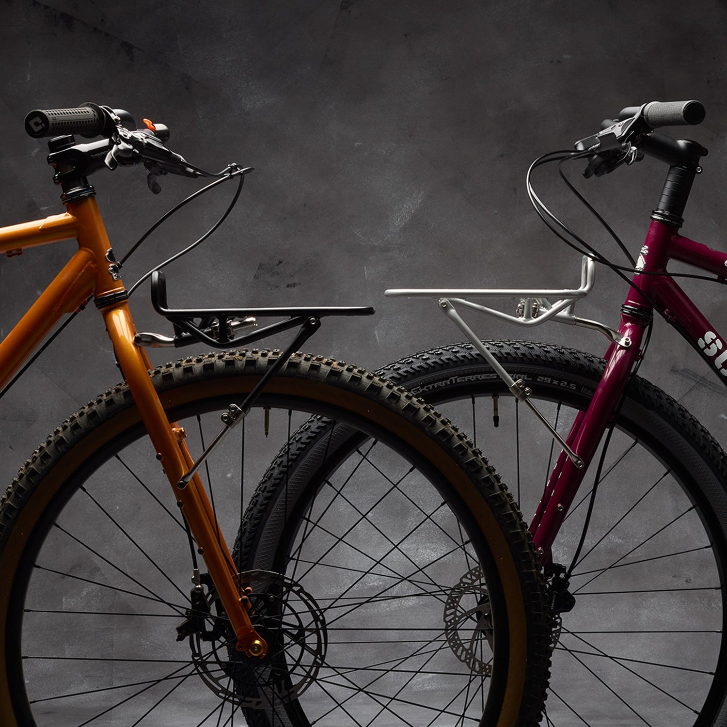 Two Surly bikes, both with front cargo racks installed, front wheels facing each other.