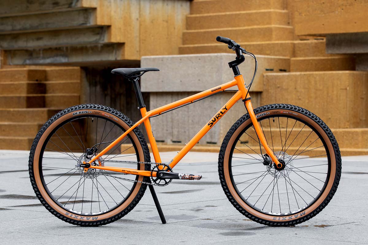 Surly Lowside bike side view. Dream Tangerine color, concrete steps in background
