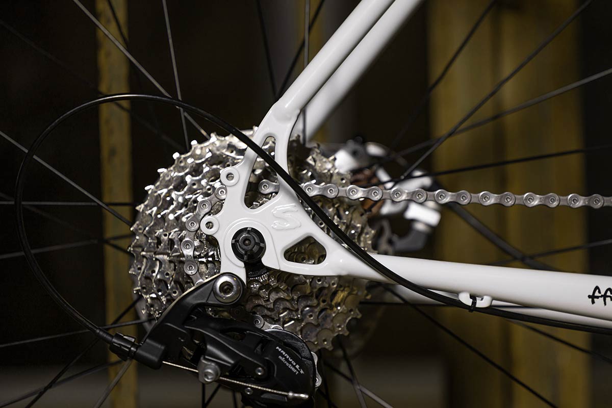 Preamble Drop Bar Thorfrost White bike, close-up of drive-side rear dropout, cassette, and derailleur