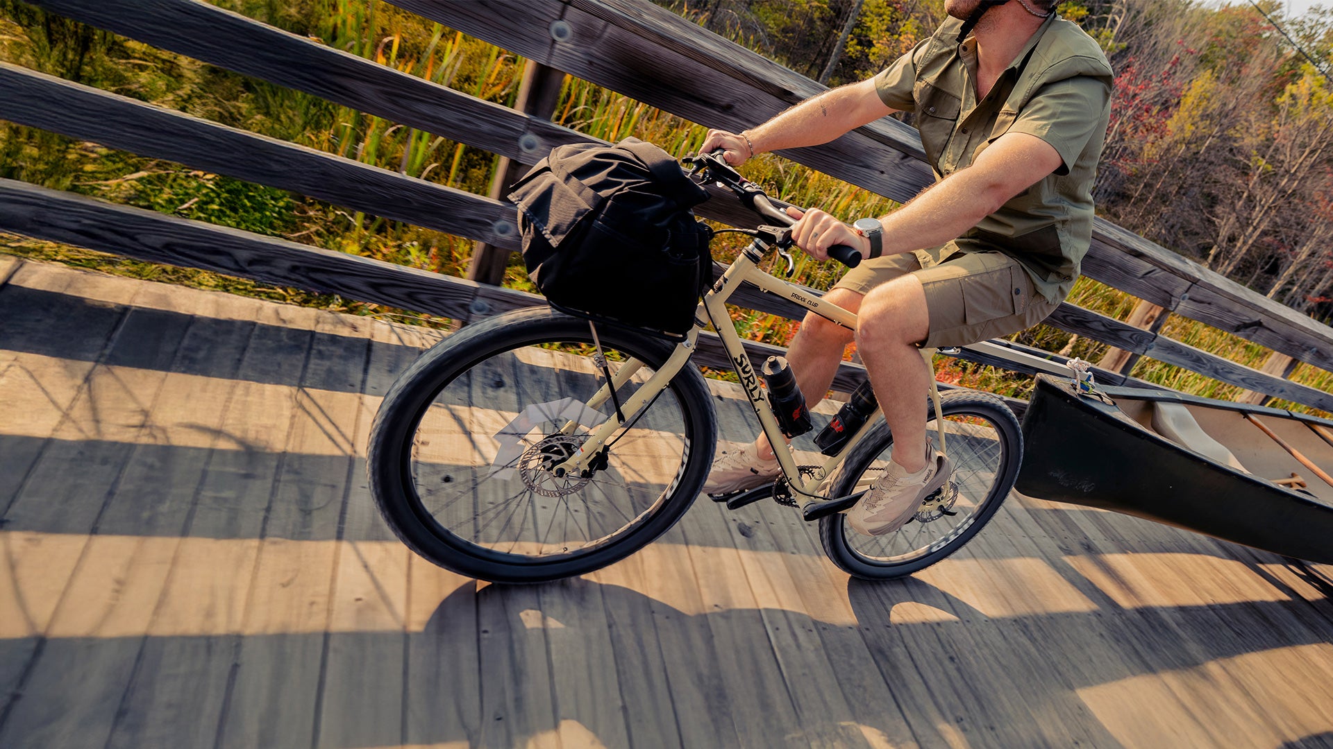 Person riding Surly Bridge Club bike on bridge towing canoe