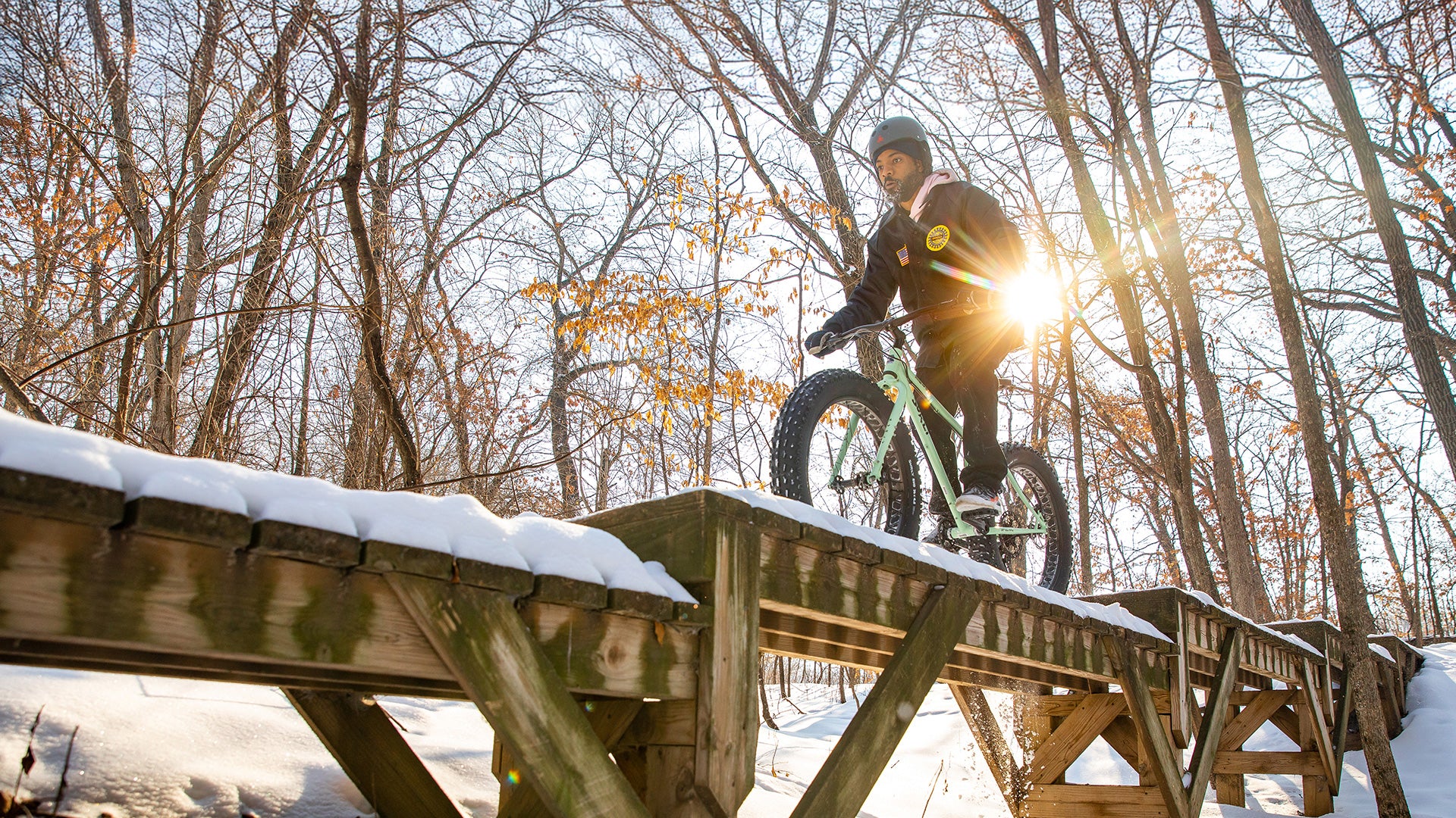 Person riding Surly Ice Cream Truck on snowing trail stunt