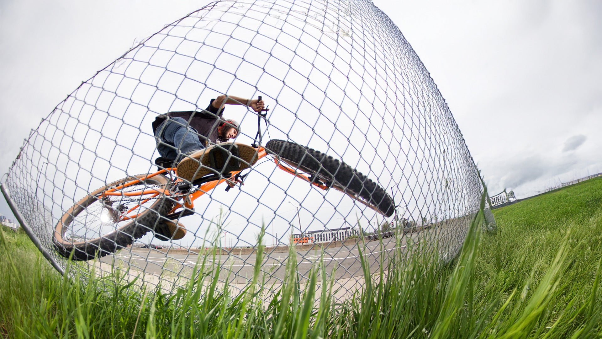 Person riding Surly Lowside using chain link fence as wall ride