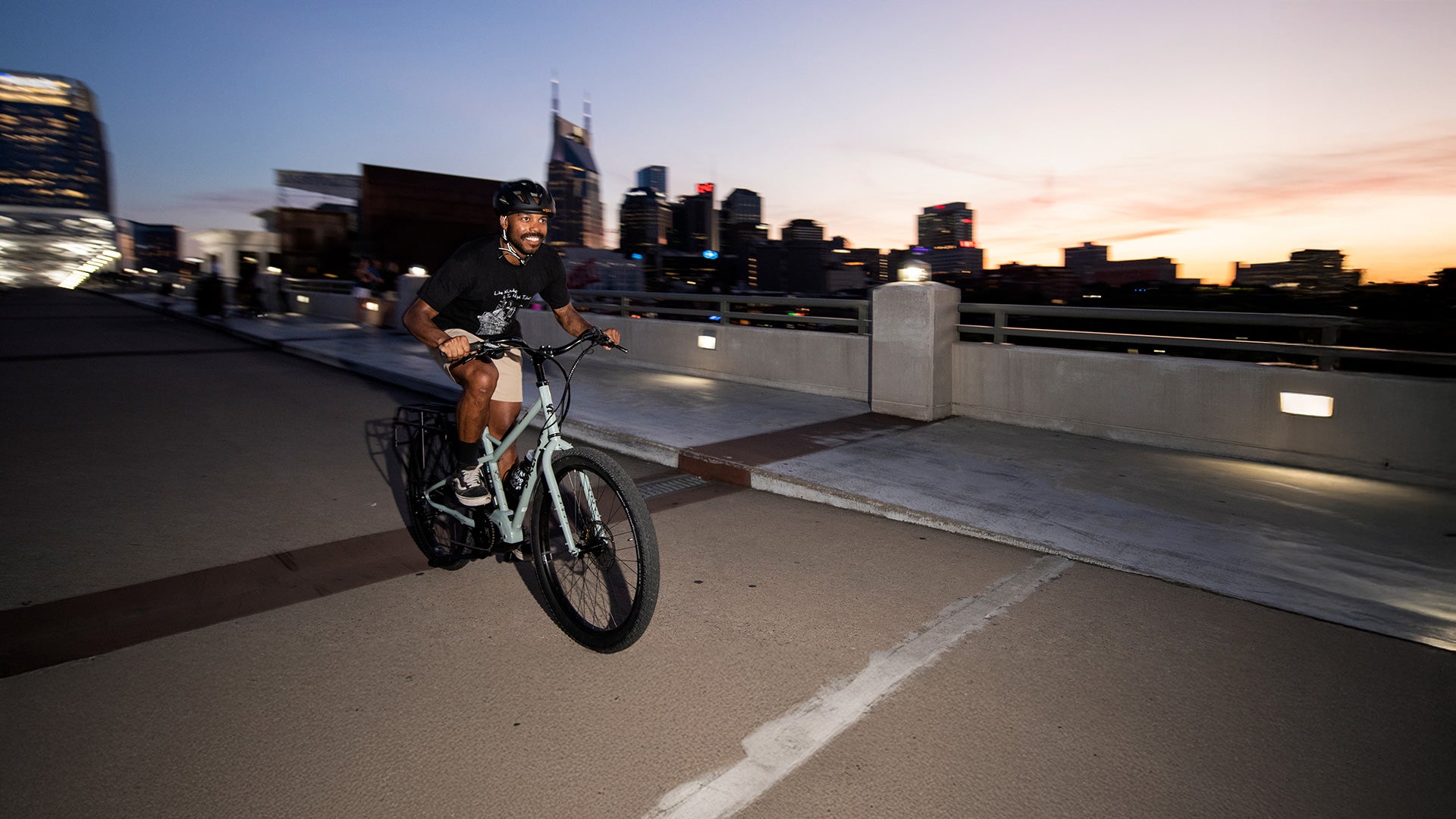 Person riding Surly Skid Loader on bridge at dusk