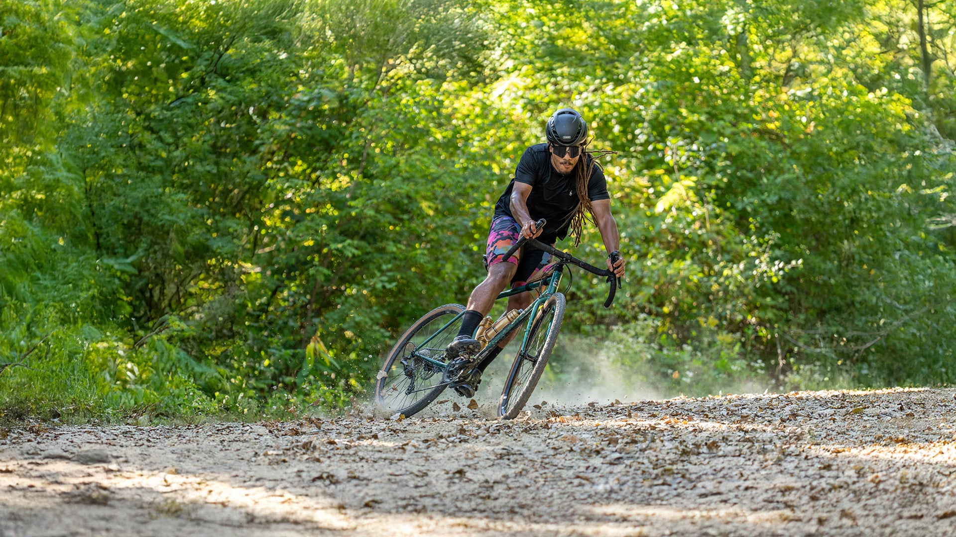 Cyclist riding Surly Straggler and skidding on gravel road