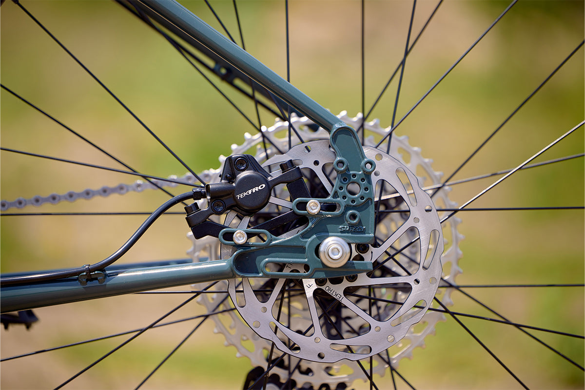 Surly Ogre bike focus on non-drive side rear dropout showing disc caliper and rotor