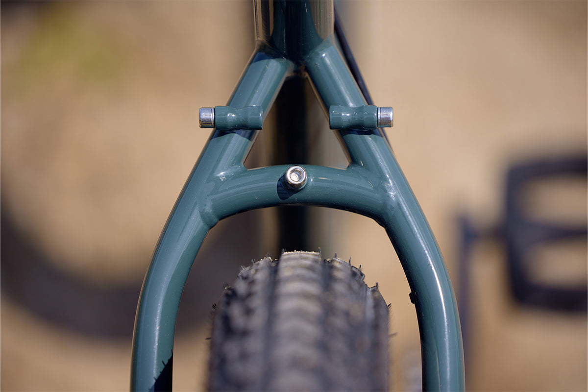 Surly Ogre bike focus on rear tire clearance between seat stays showing fender and rack mounts too