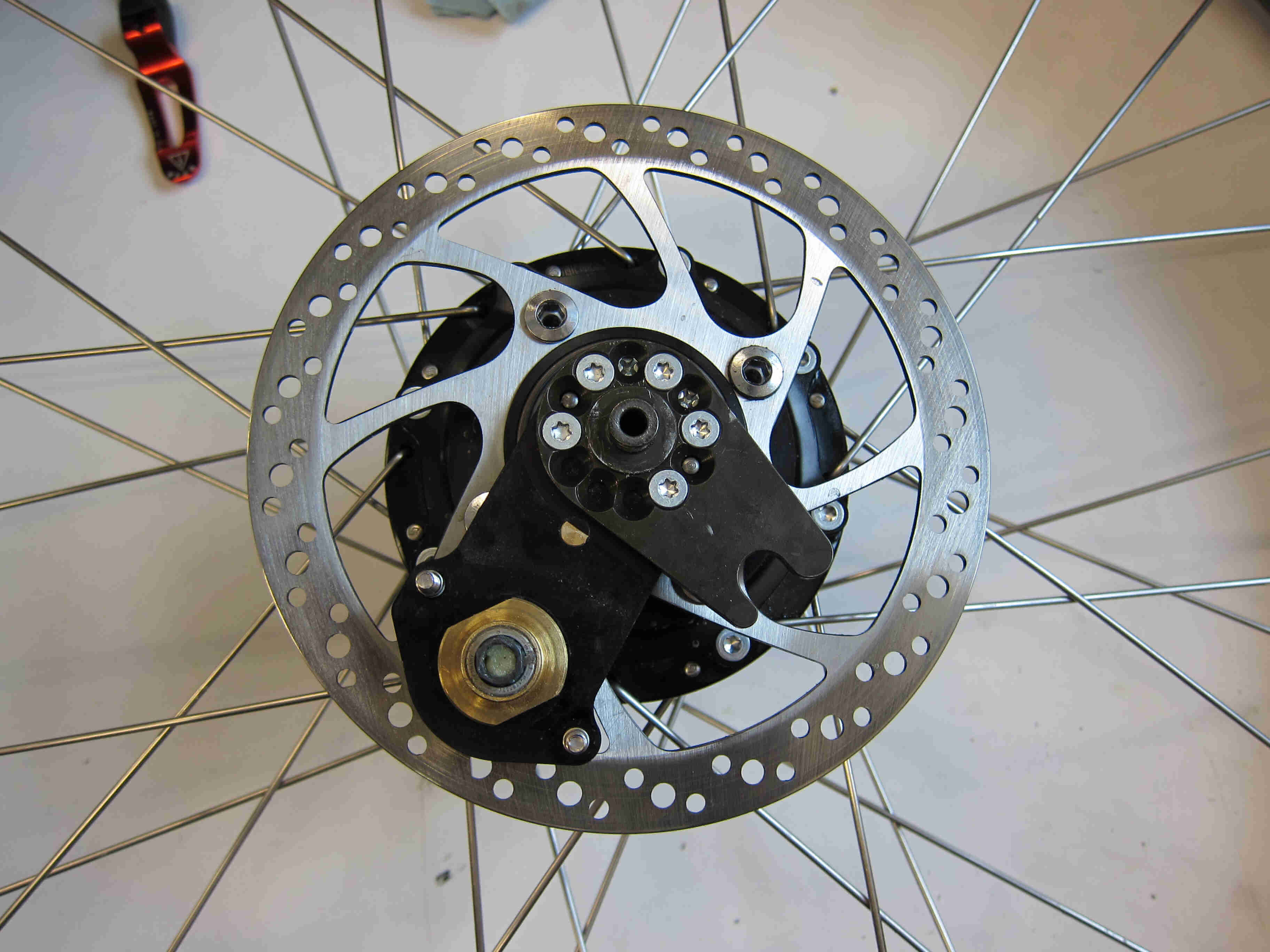 Downward view of a Rohloff bike hub with spokes and a brake disc attached