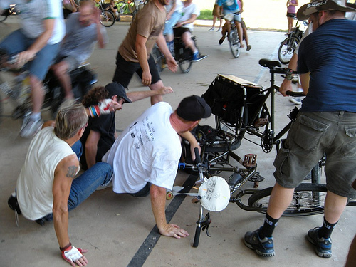 Front view of a Surly Big Dummy bike, on it's side with a cyclist and another person, after a crash on an outdoor court