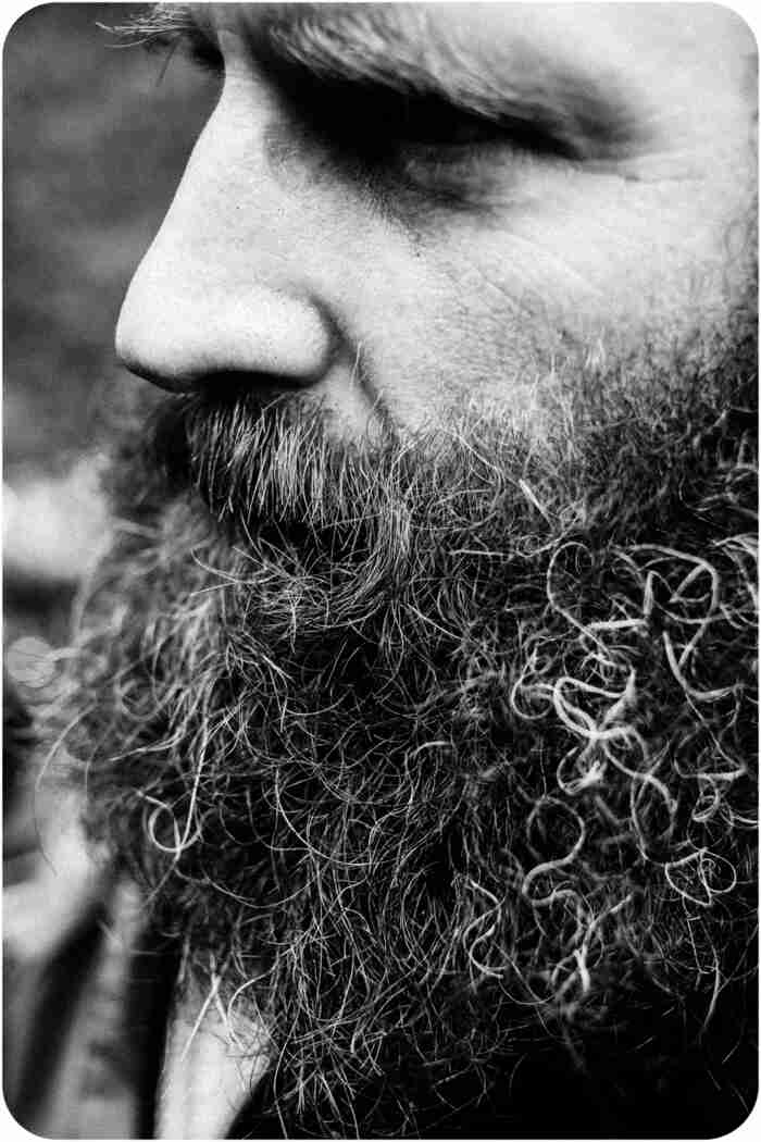 Left side headshot of a person with a thick beard - black & white image