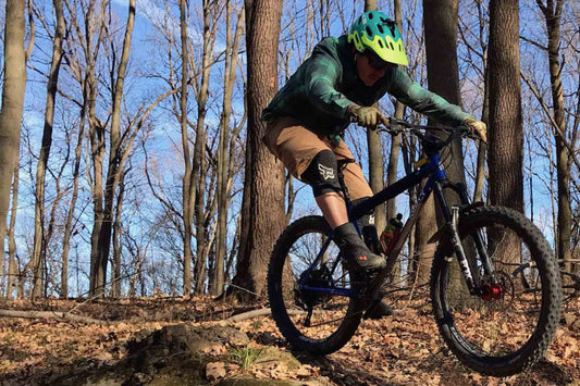 Humanoid of Surly Aaron Dixon riding mountain bike in woods