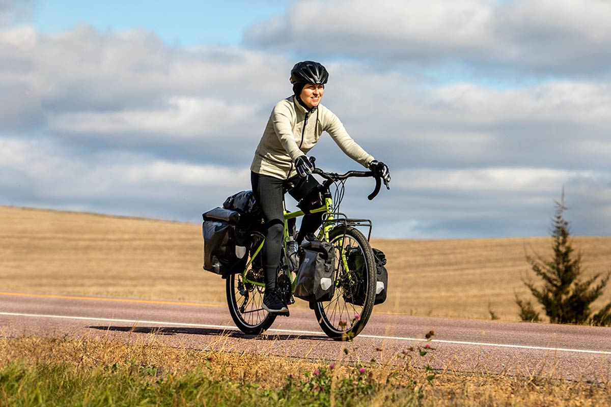 Person riding Disc Truckers bike full loaded with front and rear pannier bags on side of country road