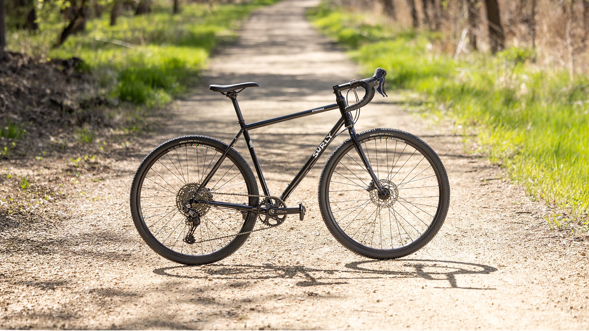 Black Surly Straggler bicycle on a dirt path in a natural setting
