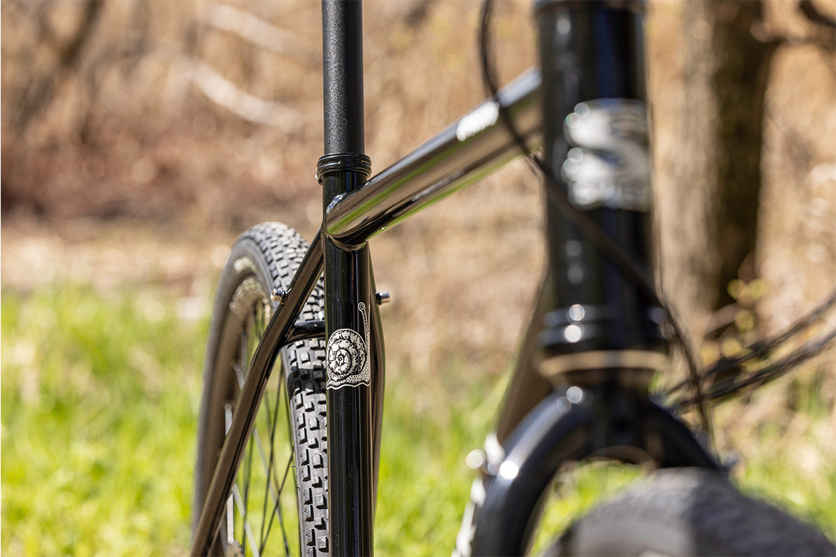 Close-up of a bicycle frame with a blurred natural background