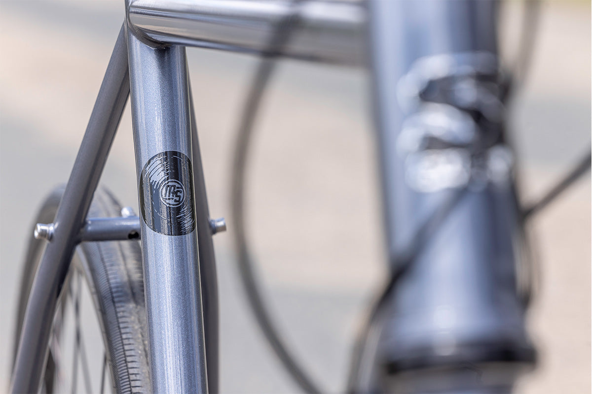 Close-up of a bicycle frame with a brand logo on a blurred background