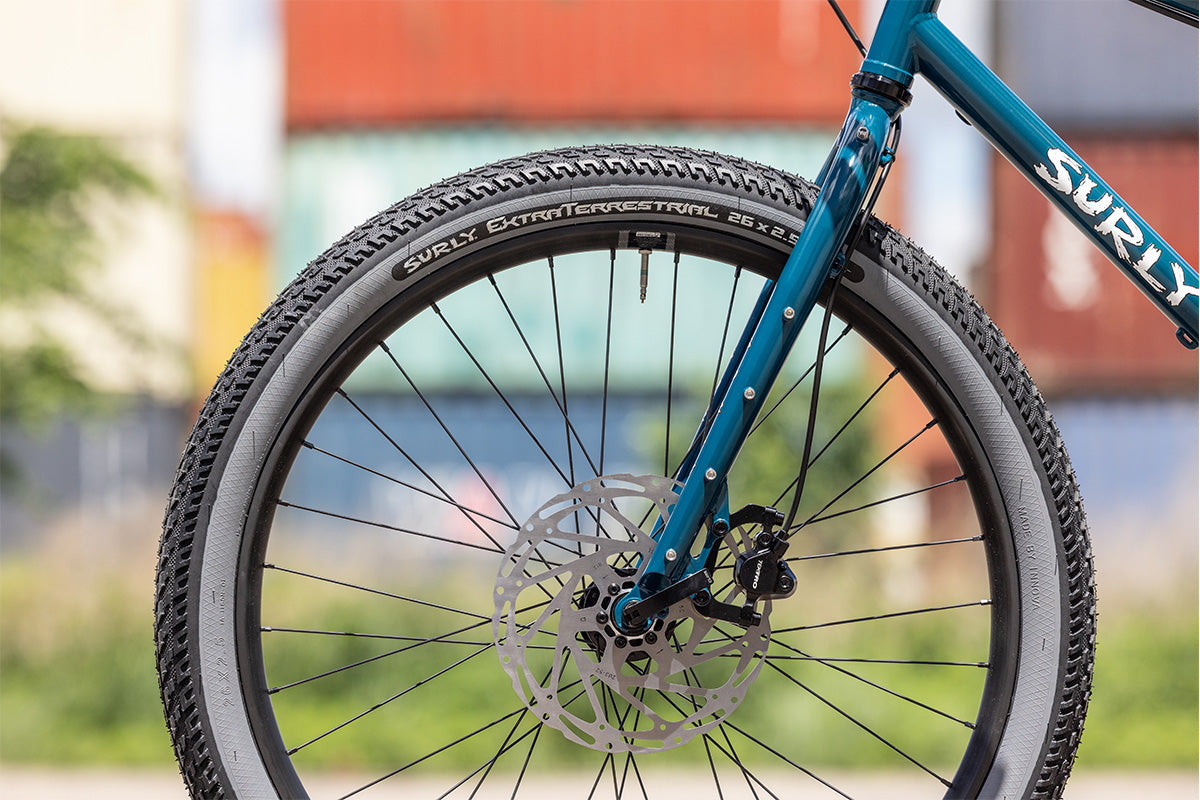 Surly Big Dummy cargo bike fork and front wheel detail outside with blurred background
