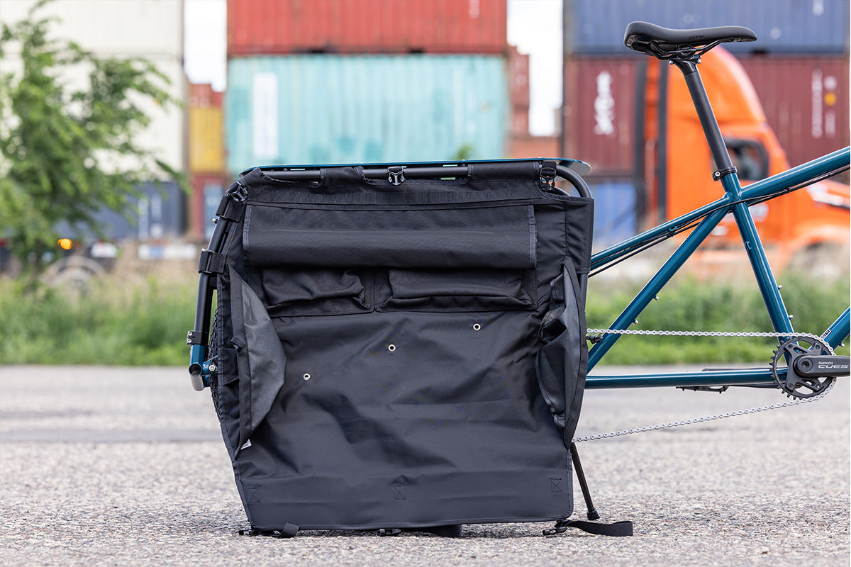 Surly Big Dummy cargo bike detail showing bags open with interior pockets outside in parking lot