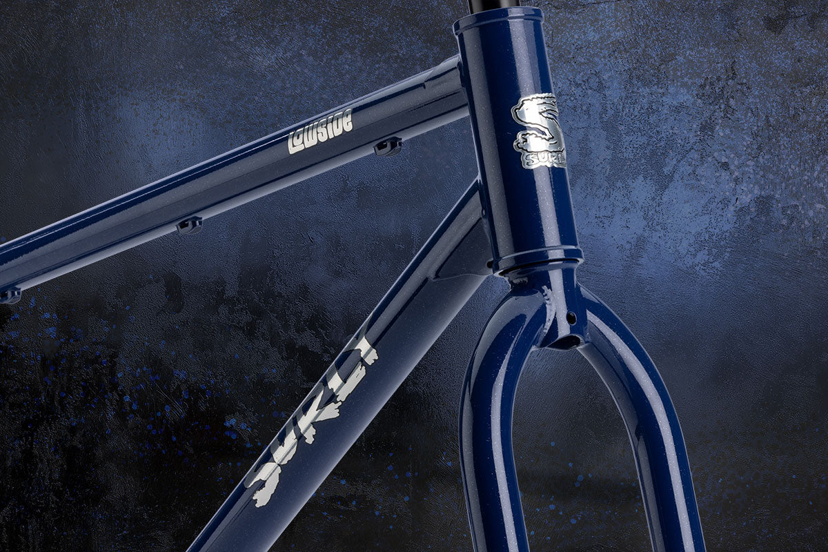 Close-up of a bicycle frame with 'Surly' branding on a dark background