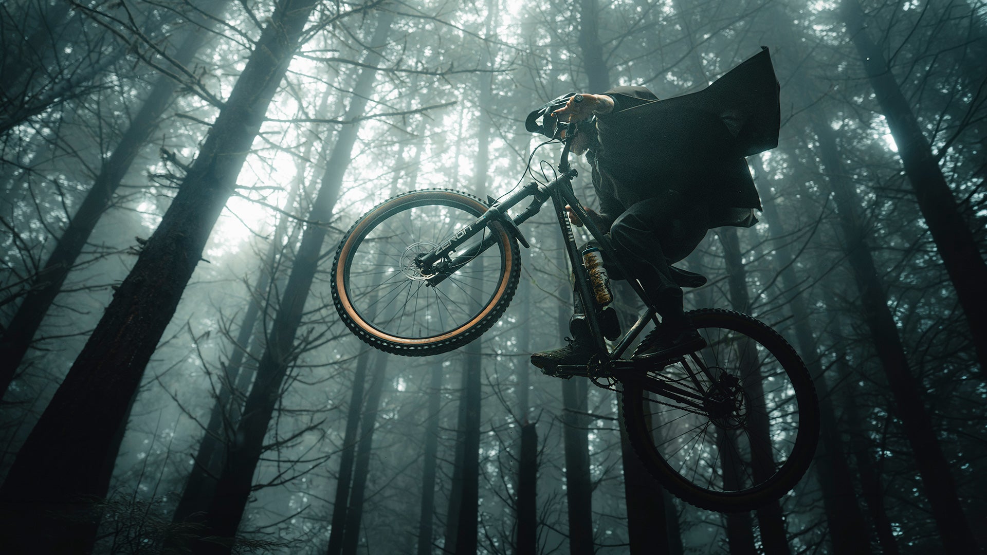 Person on a mountain bike in a foggy forest