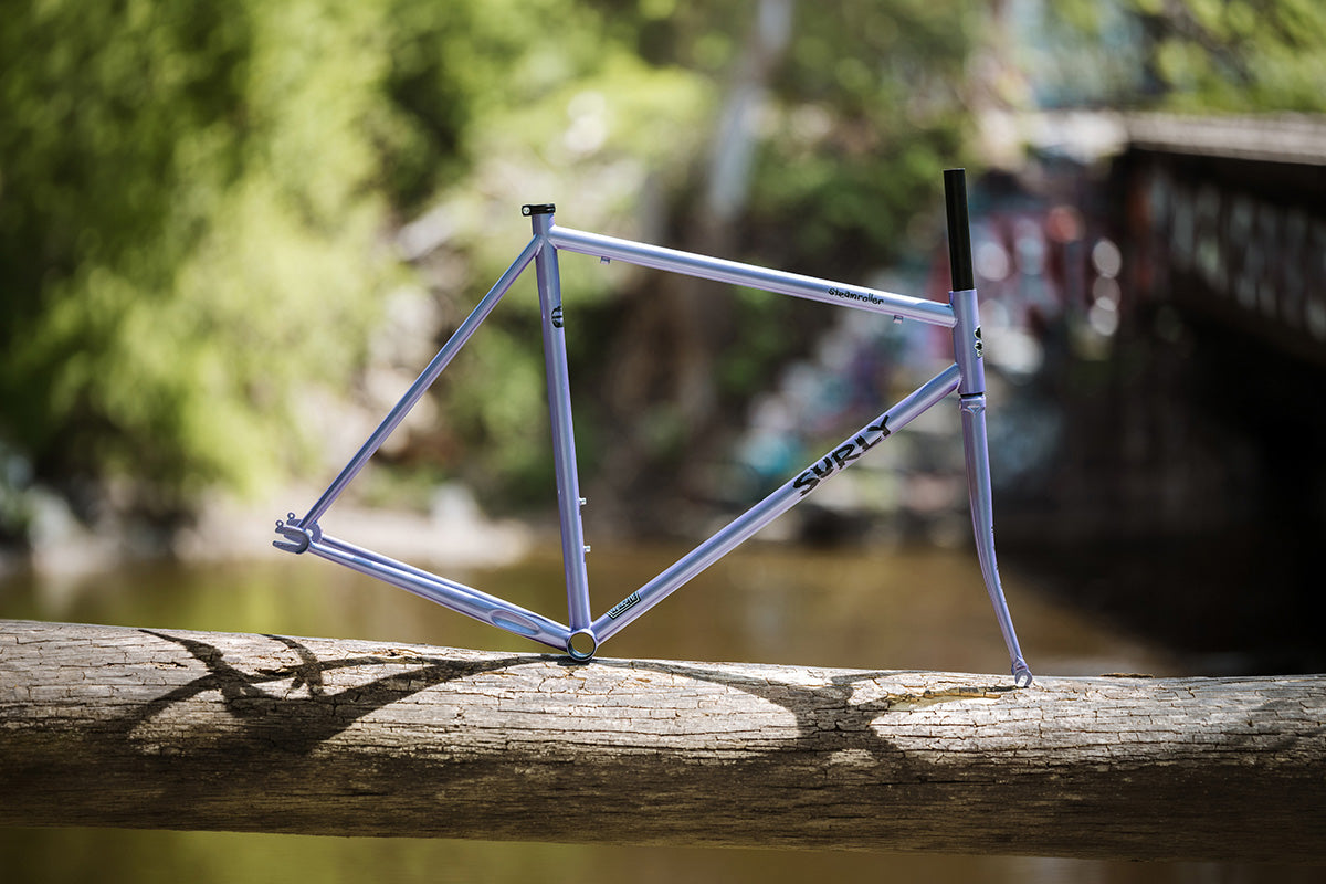 Surly Steamroller frame on a log with a blurred natural background
