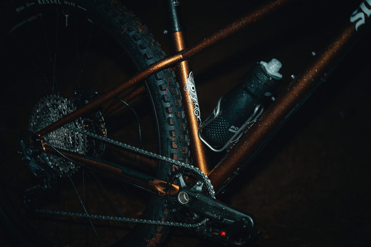 Close-up of a bicycle's chain and gear system on a dark background