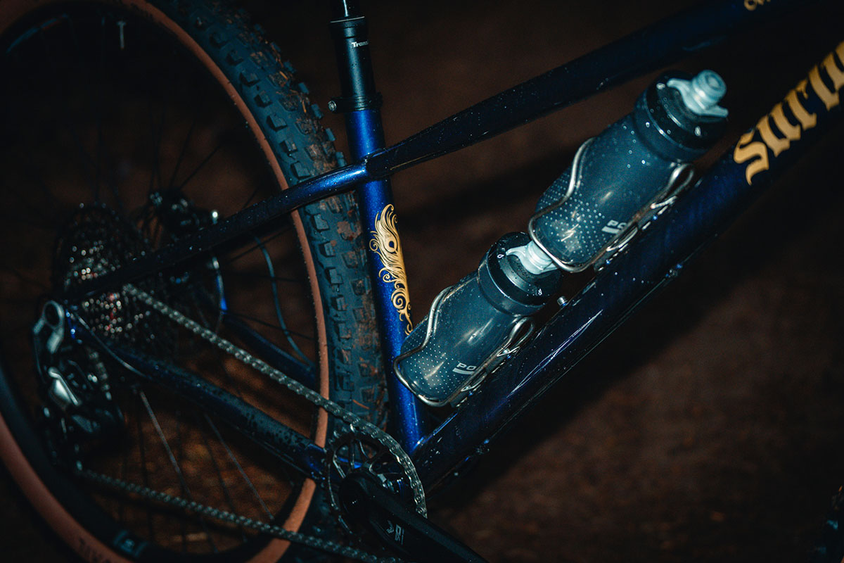 Close-up of a bicycle with a water bottle attached, featuring the Surly brand.