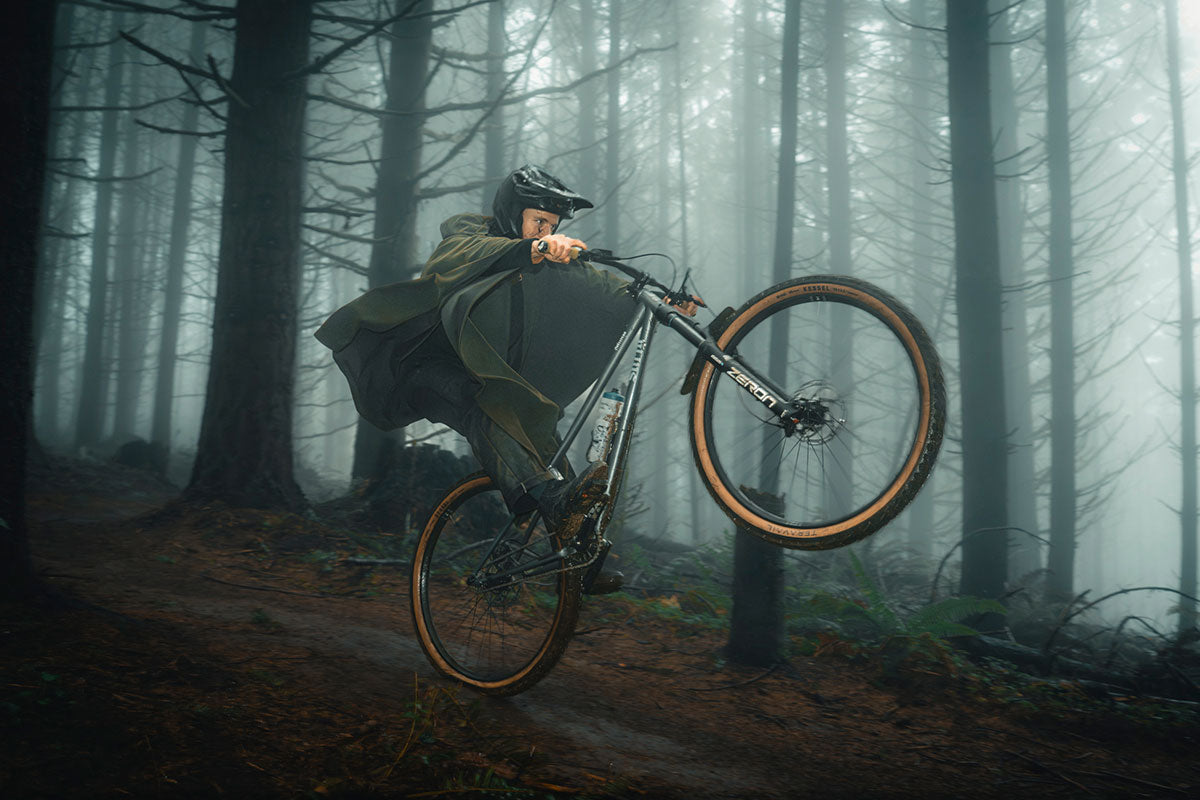 Person riding a bicycle through a foggy forest