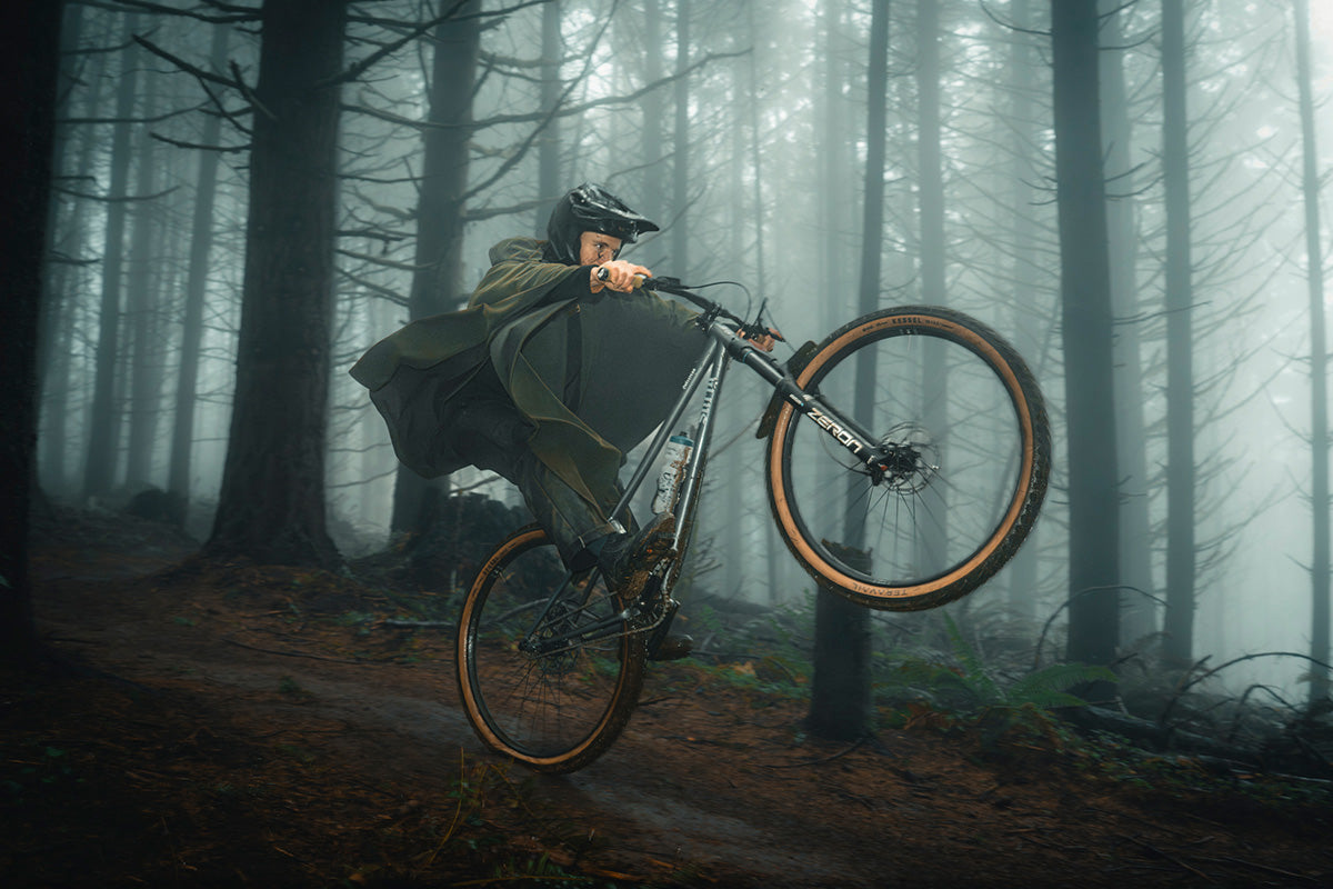 Person riding a bicycle through a foggy forest