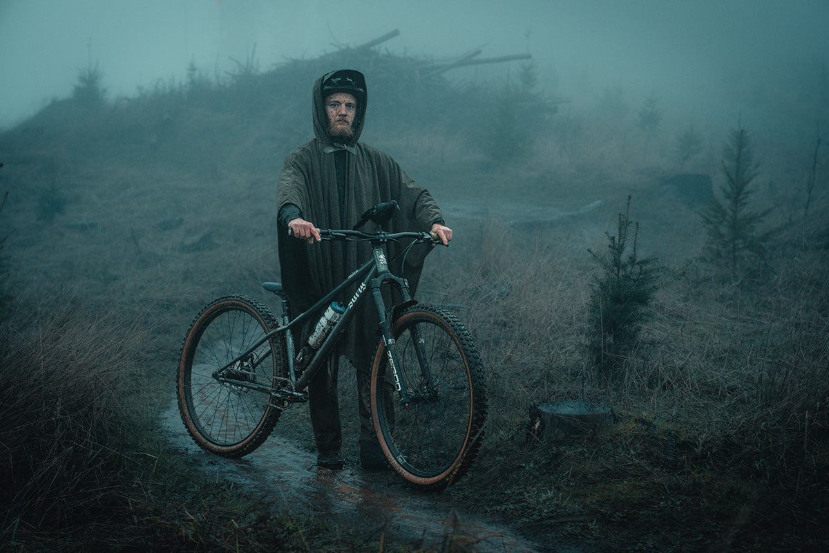 Person with a mountain bike in a foggy, forested area
