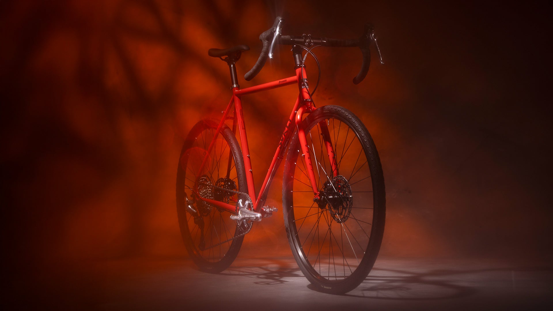 Surly Preamble Drop Bar bike in Red Hot Cheddar against a dark background with a warm light source