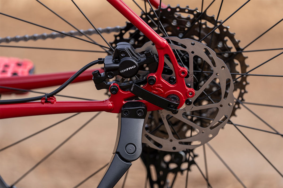 Close-up of a bicycle's disc brake system with red and black components.