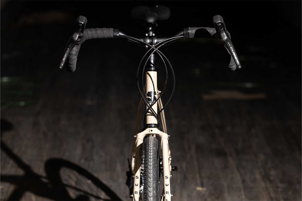 Surly Disc Trucker bike in Grandpa's Khakis color straight-on front view on dark background