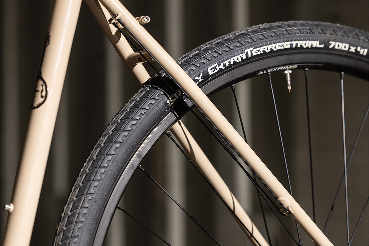 Close-up of a bicycle tire with 'Extra Terrestrial' branding on a blurred background
