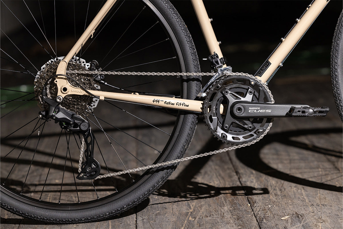 Close-up of a bicycle drive train on a wooden surface