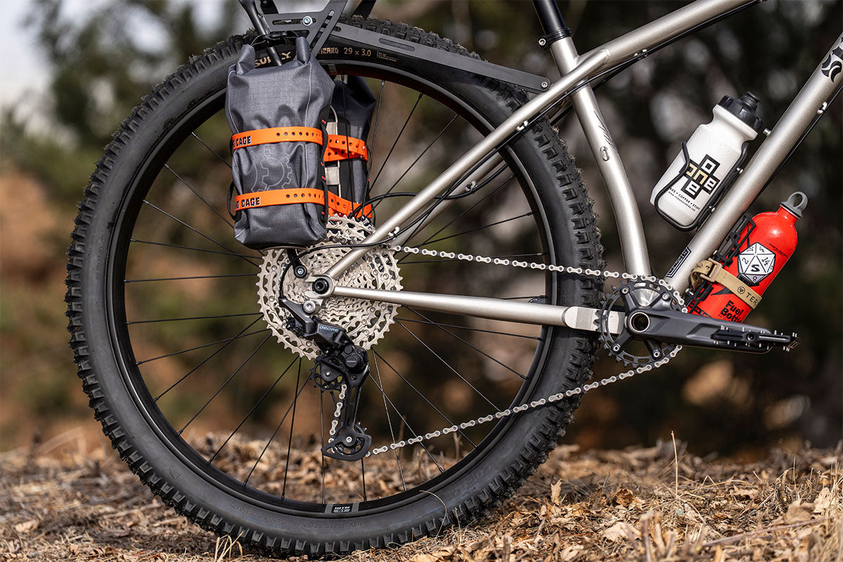 Close-up of a mountain bike with gear and a water bottle on a natural background