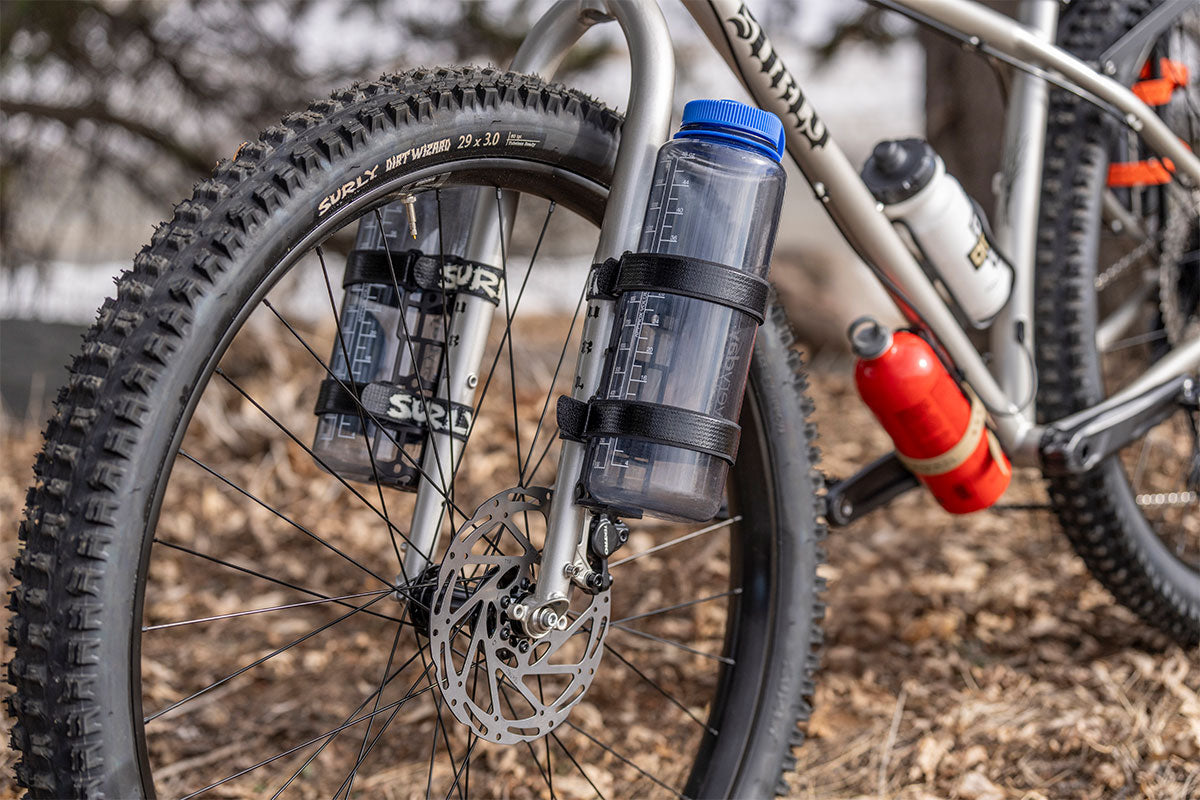 Bicycle with water bottles attached to the frame, parked outdoors.
