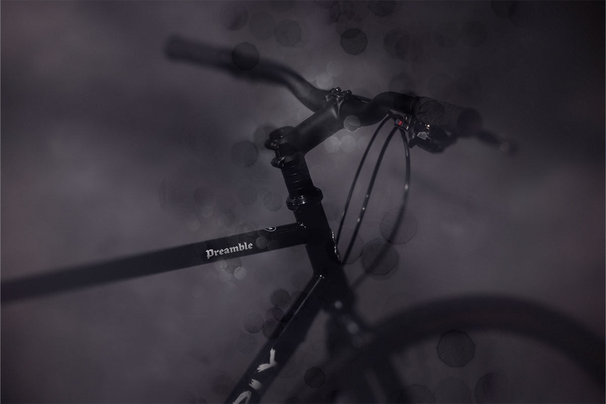 Close-up of a bicycle handlebar with 'Preamble' branding on a dark background
