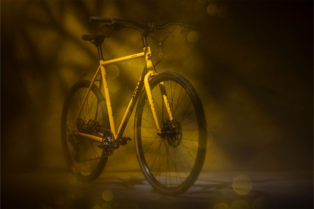 Yellow bicycle on a dark background with a warm filter