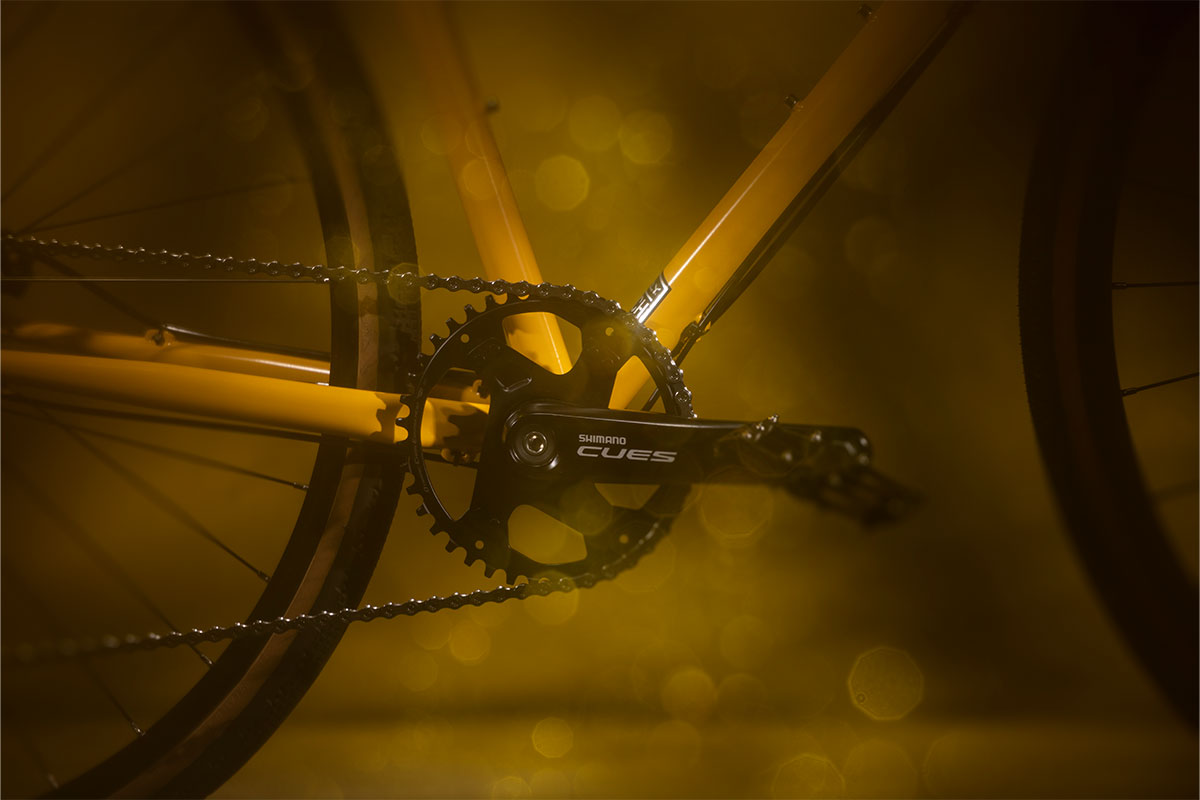 Close-up of bike single ring crankeset on yellow bike with dark background