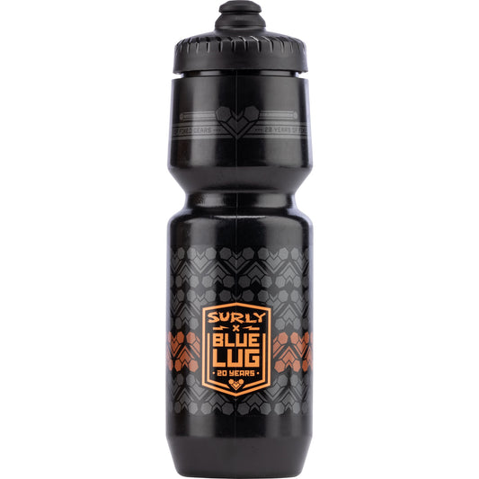 A black Surly x Blue Lug 20 Years water bottle with a black screw cap, featuring a central orange and black shield logo and a subtle geometric pattern on the lower half.