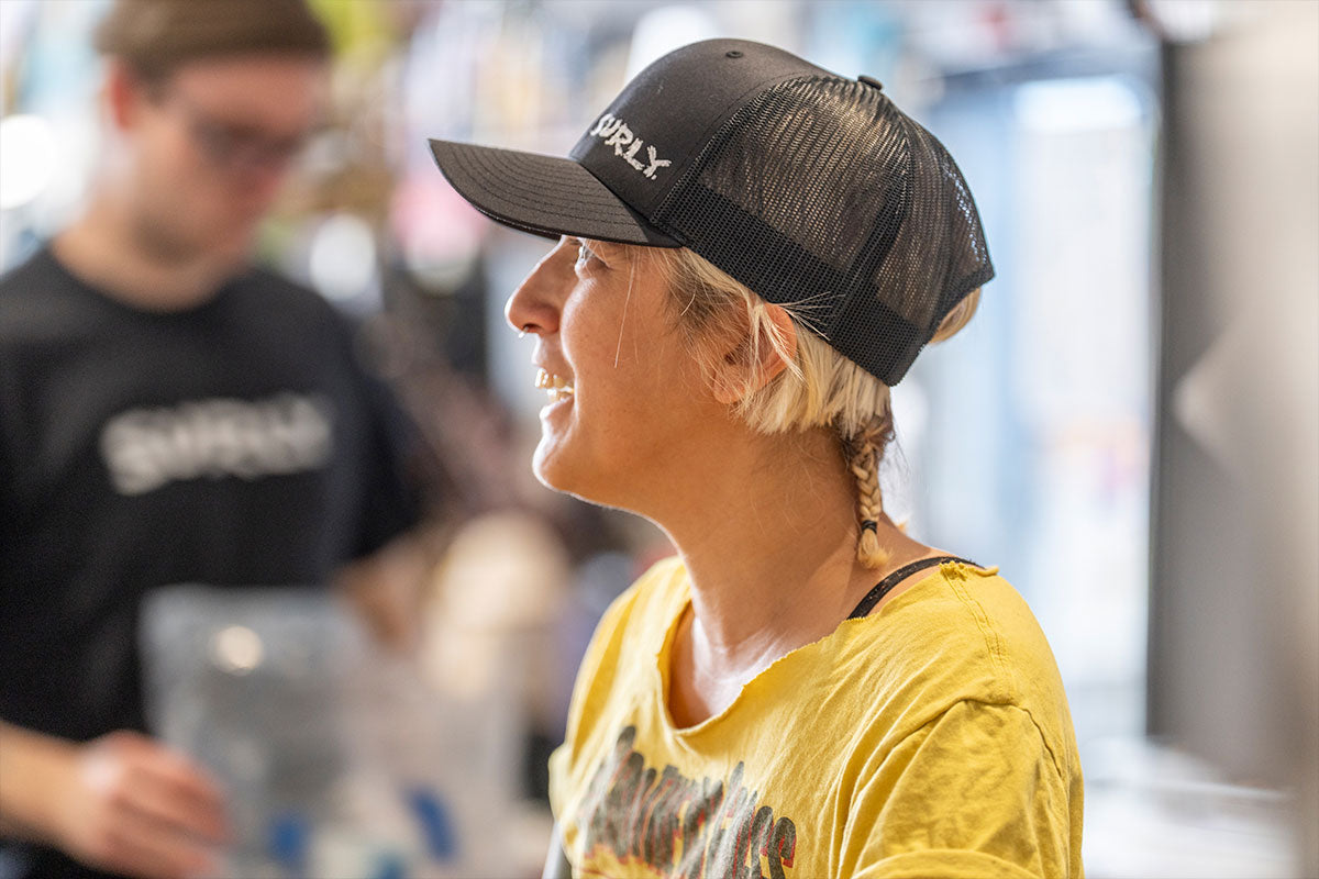 Person wearing black Surly logo hat in shop