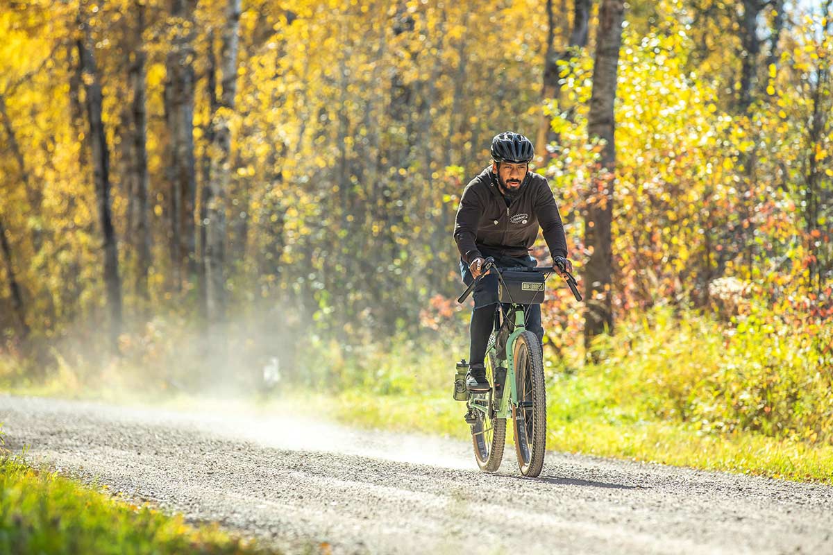 Person riding Grappler on forest gravel road in sunshine