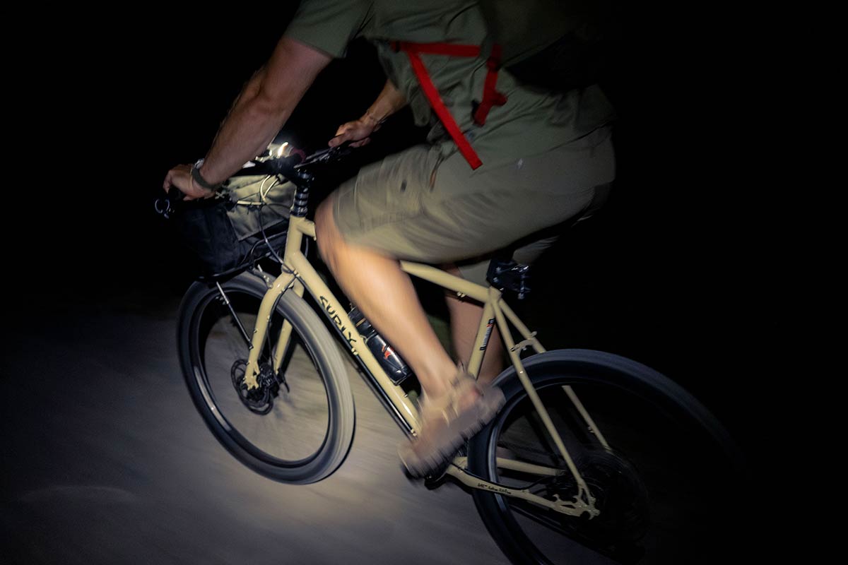 Cyclist riding Surly Bridge Club bike at night with light focused on bike