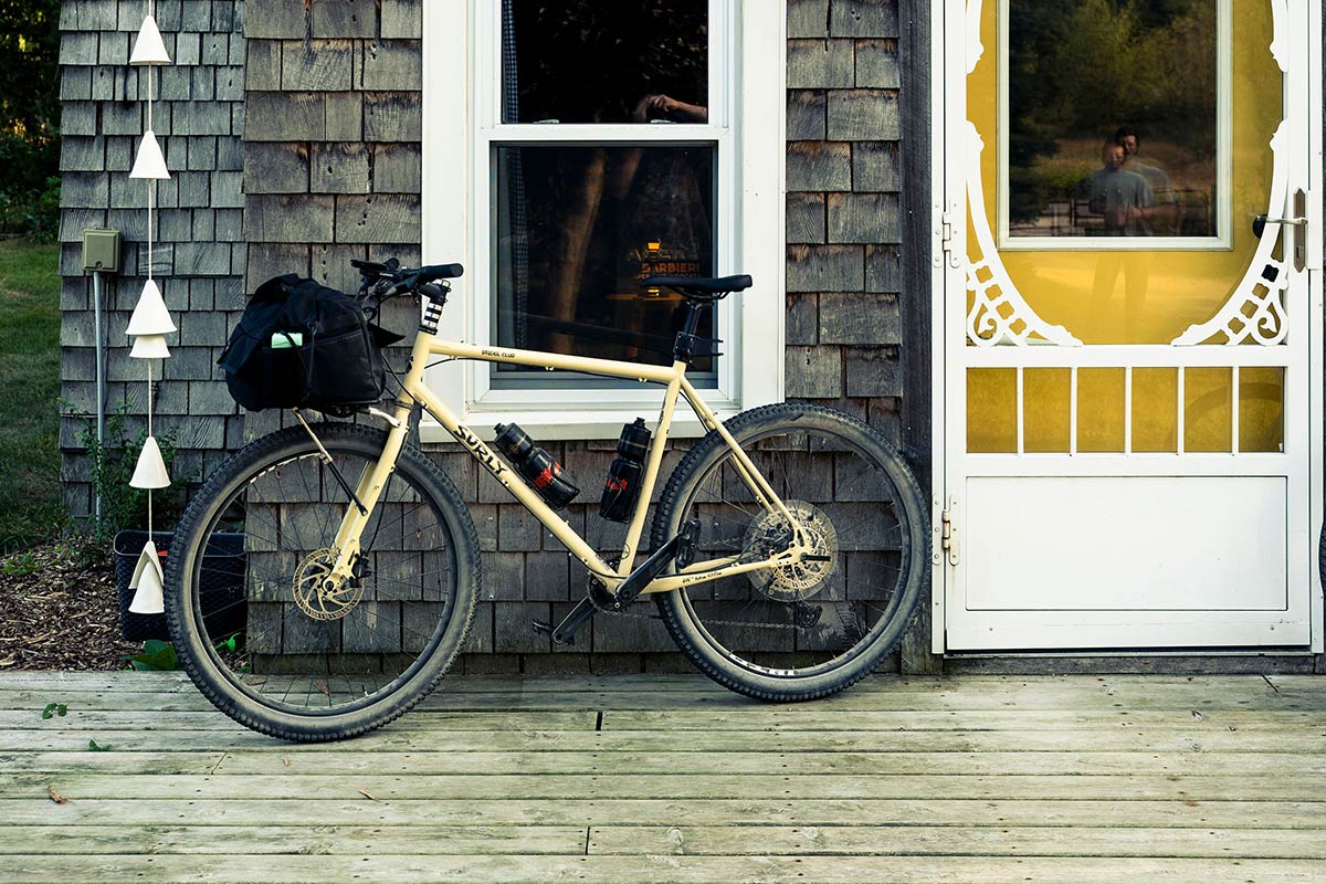 Surly Bridge Club bike with front rack and bag parked against house