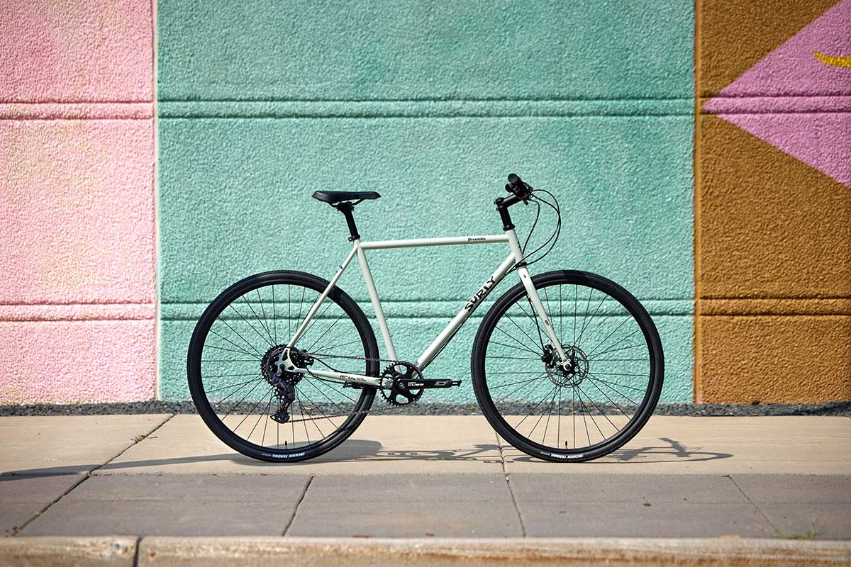 Surly Preamble Flat Bar Best Buds Green bike side view on on sidewalk up against colorful painted building