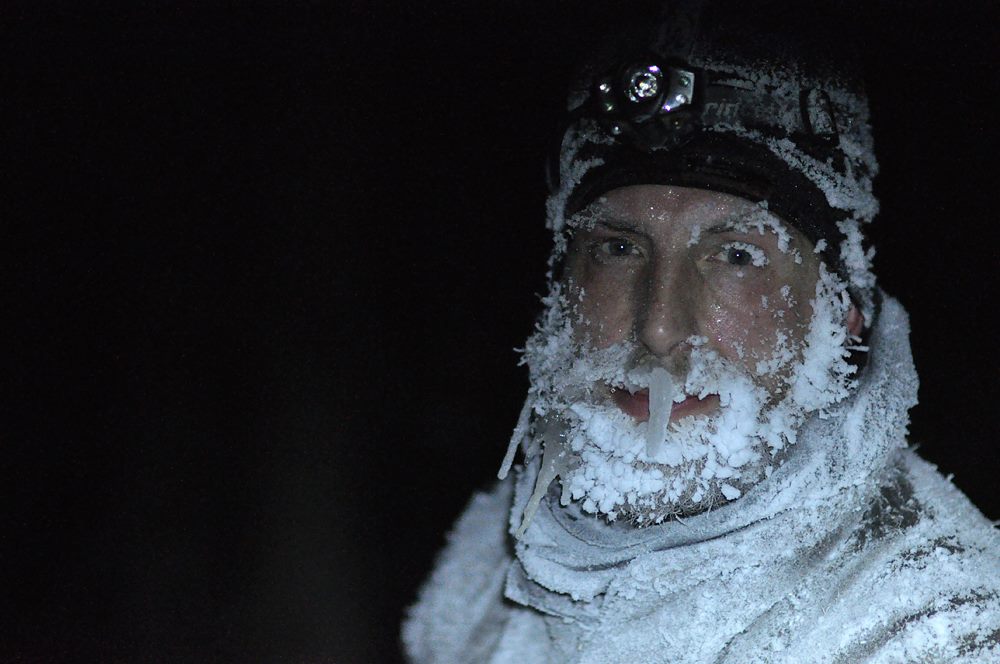 Front view a person with a frost covered face at night