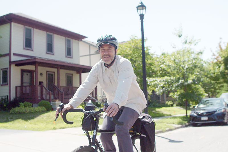 Matt riding bike in neighborhood smiling