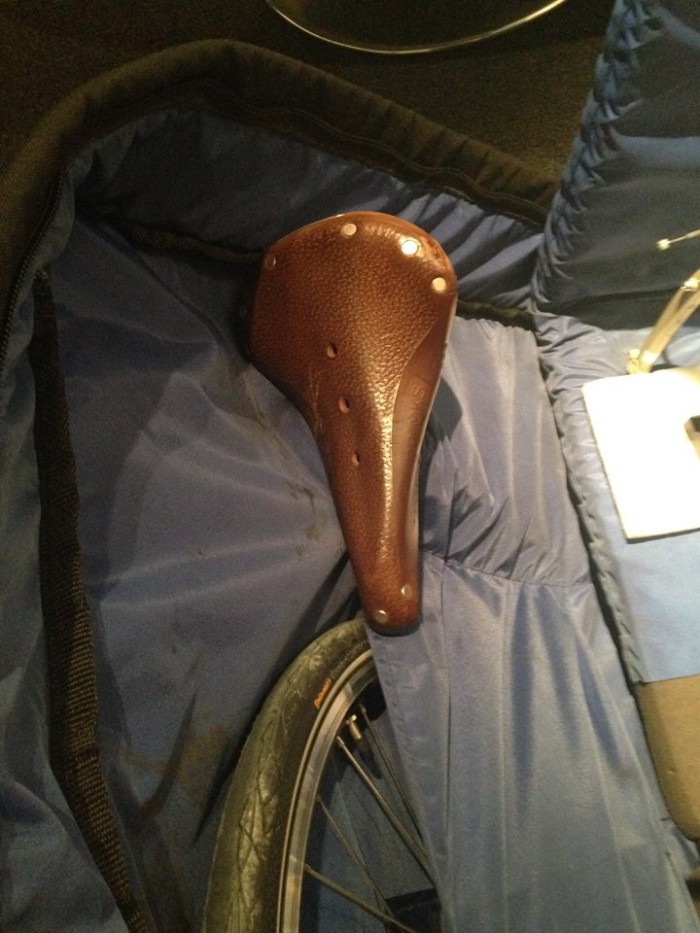 Downward view of a bike seat and post, packed into a bike carrier bag