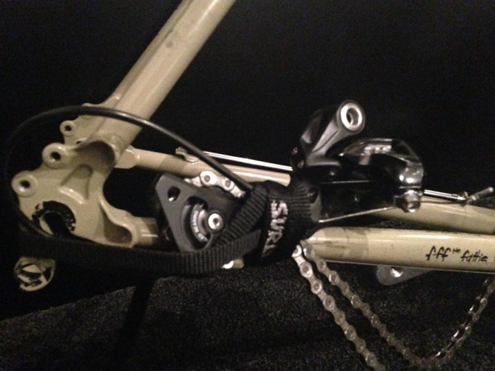 Cropped, right side view a rear derailleur, from a Surly Long Haul Trucker bike, strapped to the frame chainstay