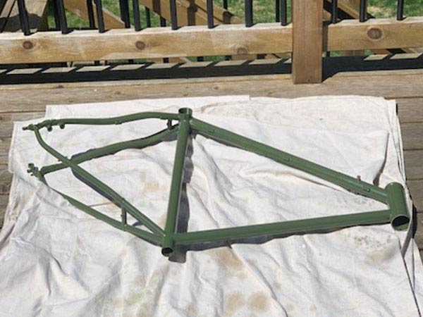 Dan's Surly Midnight Special frame painted green on drop cloth on deck