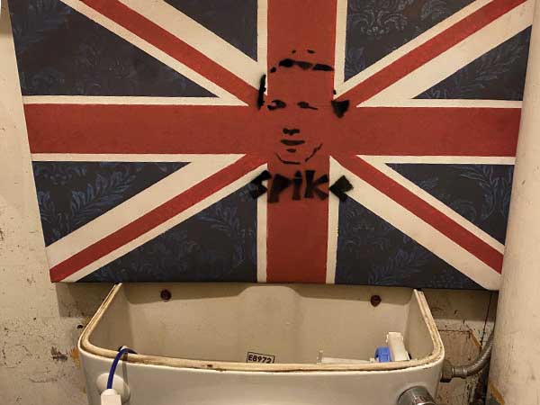 Shady toilet with British flag above tank, screen printed face and 'Spike' in center